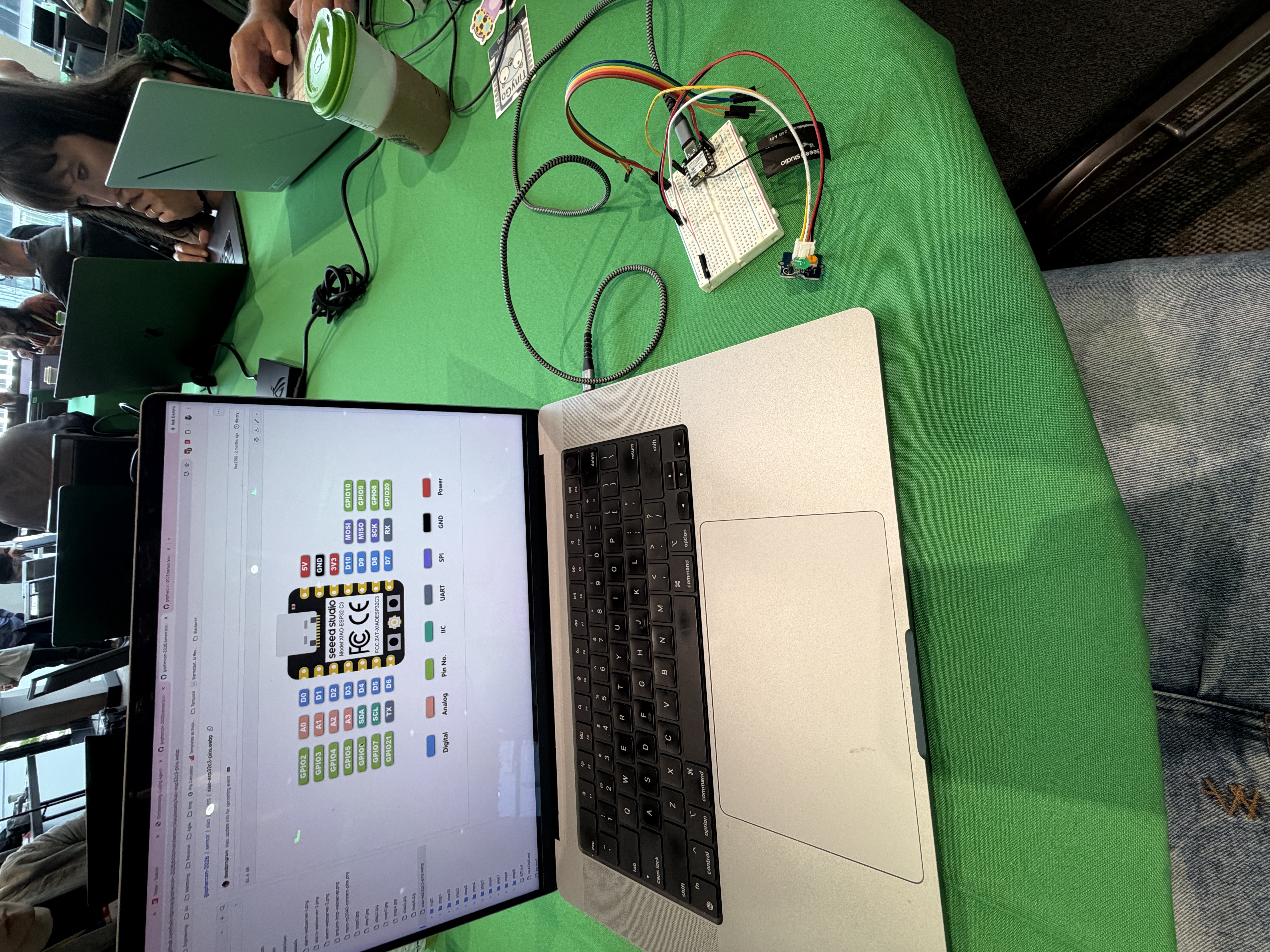 My workshop table: a laptop showing a Seeed Studio board pinout diagram, next to a breadboard wired up with jumper wires