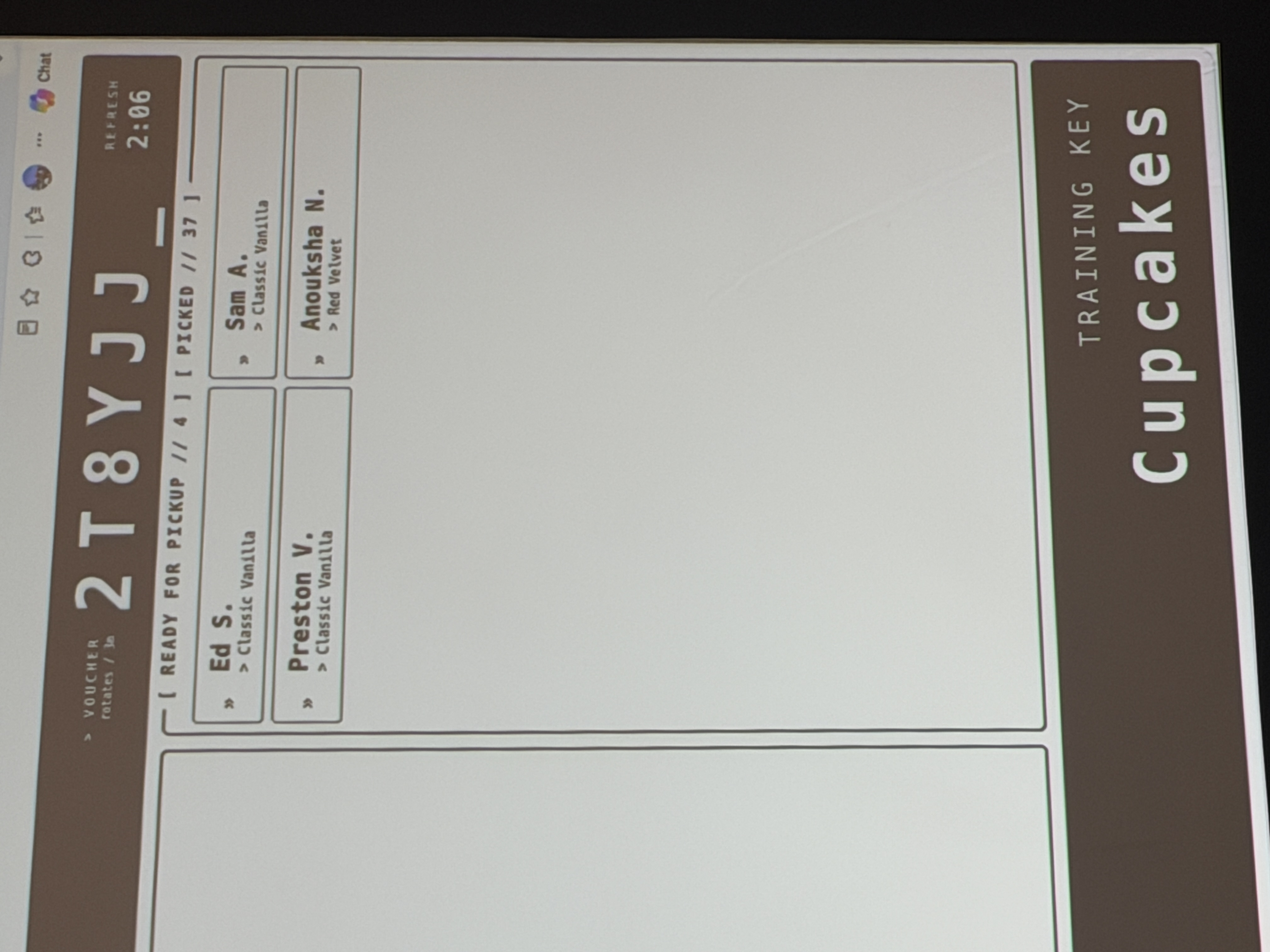 The cupcake workshop order board projected on screen, showing my order — Ed S., classic vanilla — waiting to be picked up